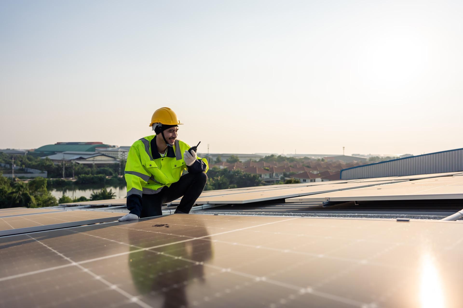 Fachkraft kontrolliert Photovoltaik-Modul auf Dach