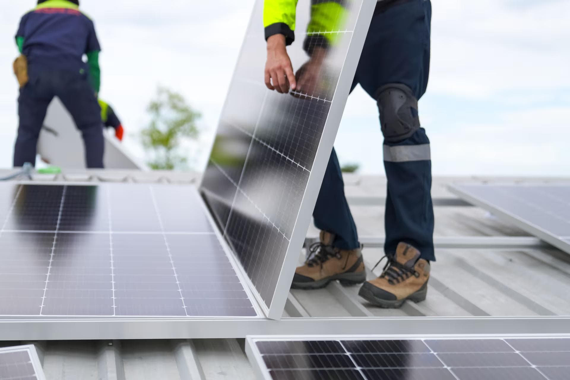Mitarbeiter installieren Photovoltaik-Anlage auf Dach