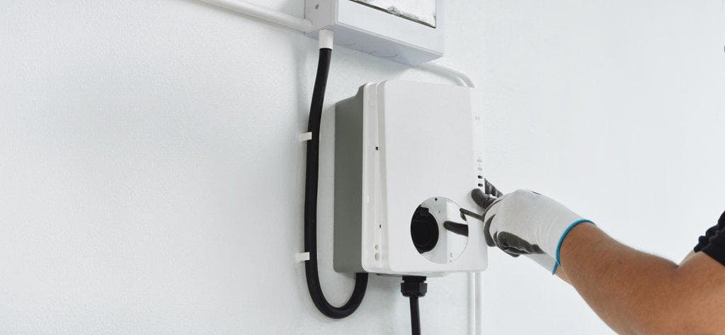 Elektriker installiert Heim-Ladestation für Elektrofahrzeuge