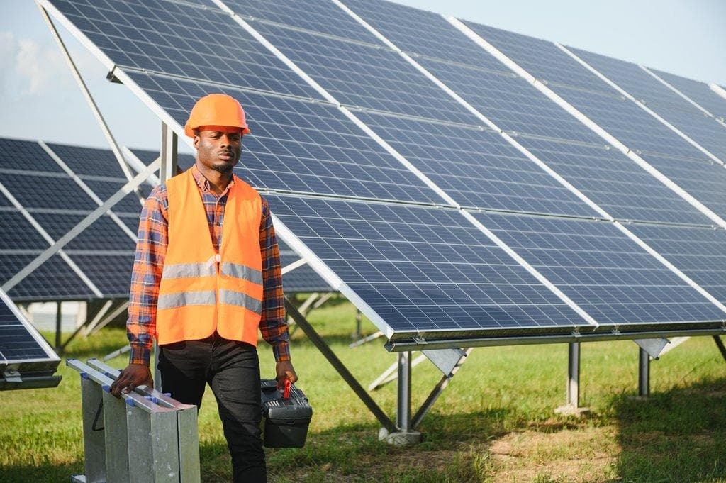 Elektroingenieur mit Sicherheitshelm bei Solarprojekt