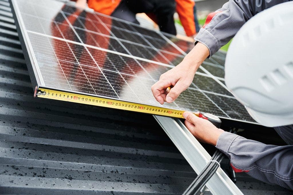 Installation von Solarmodulen auf Dach inklusive Messungen durch Arbeiter