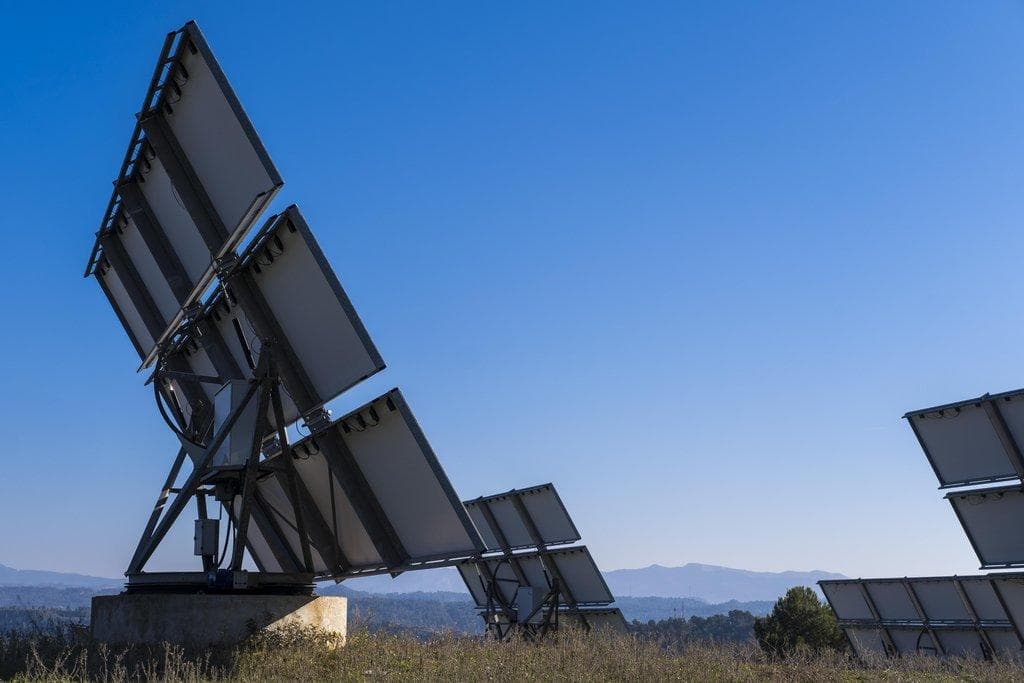 Solarzellen auf Feld vor blauem Himmel