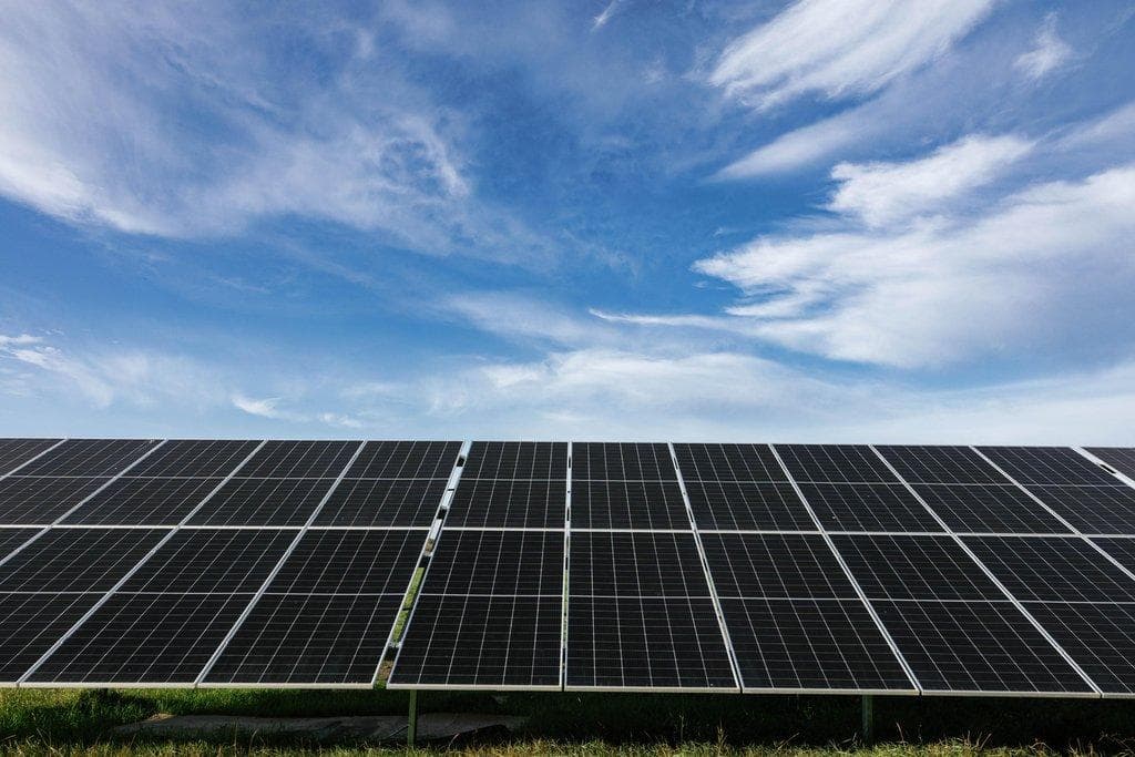 Solarpanels absorbieren Sonnenlicht unter bewölktem blauem Himmel